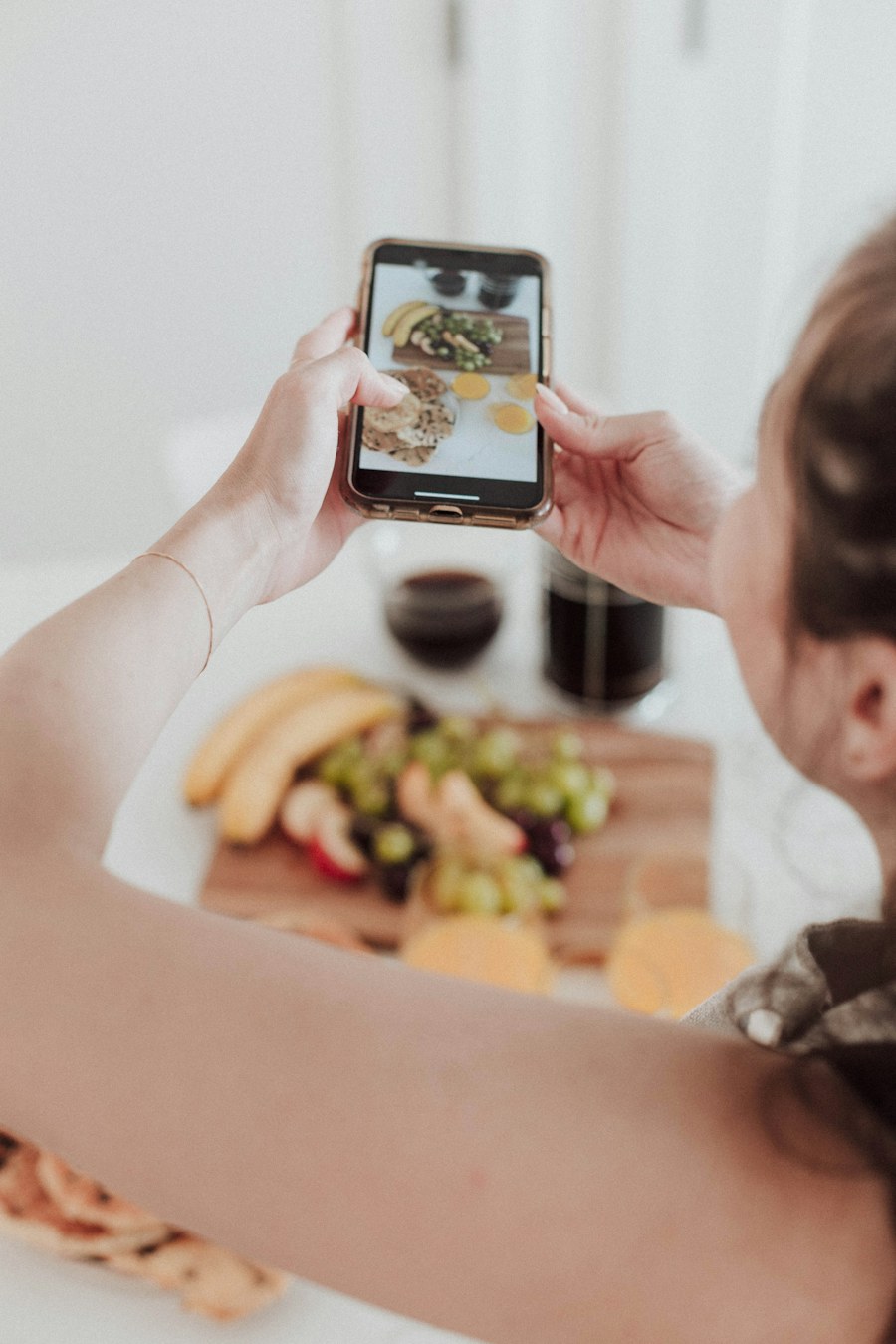 A woman photographing a grazing board on her phone